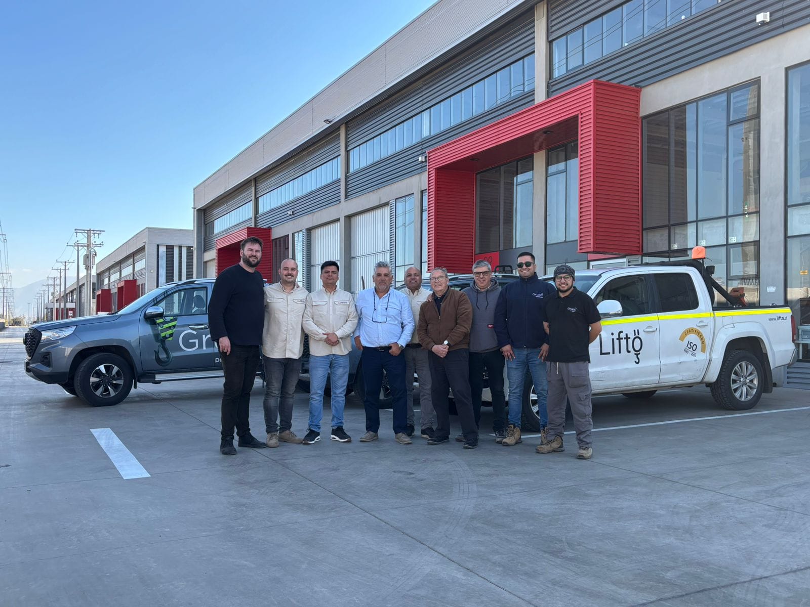 Equipo de Grupo Ocho frente a sus instalaciones